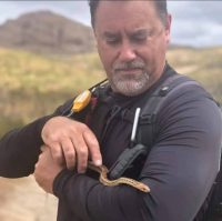 COSF board member John Noble holds a gopher snake.